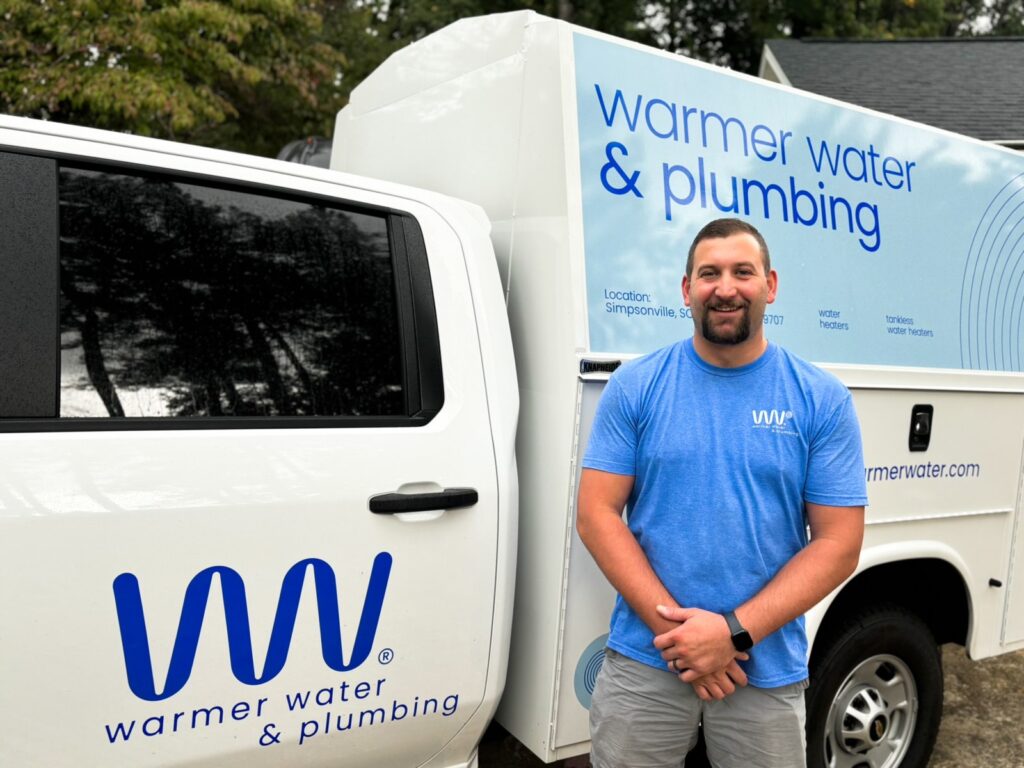 Josh, General Plumber & Water Heater Expert, in front of the Warmer Water Truck