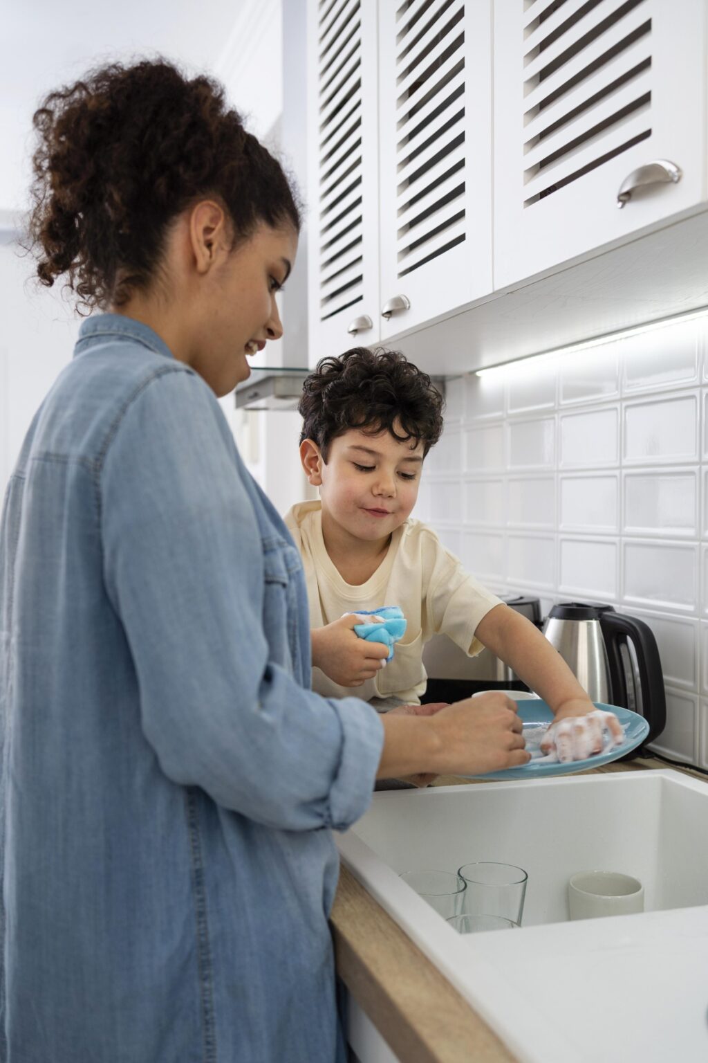 mom and kid washing dishes after general plumber repair from Warmer Water