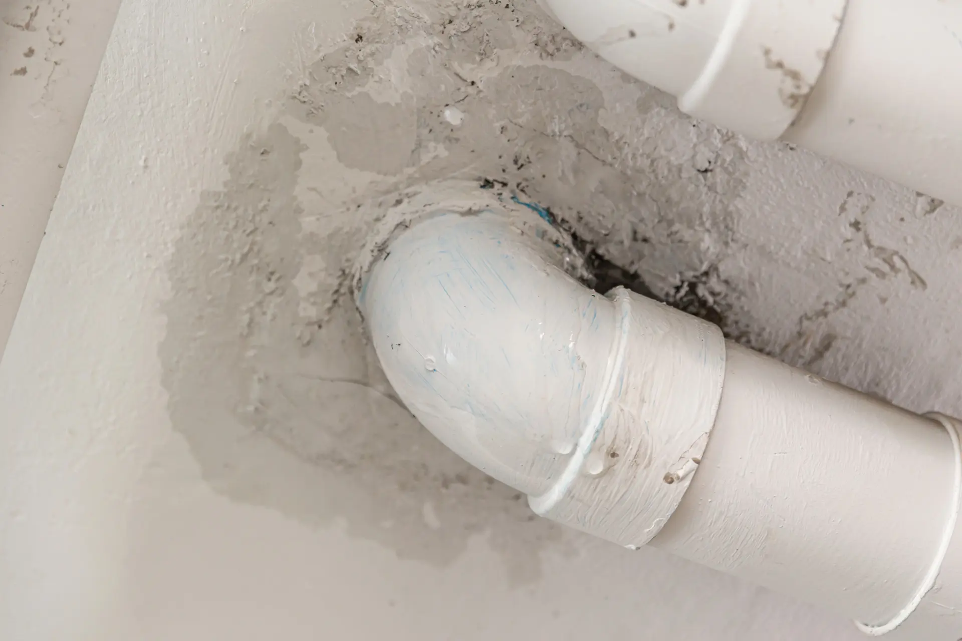 warmer-water-burst-pipe-repair-simpsonville Close-up of a PVC pipe joint showing damage before burst pipe repair