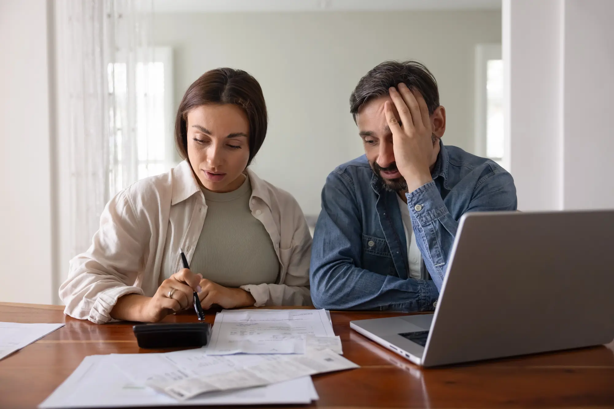 Homeowners reviewing gas versus electric tankless water heater options at home