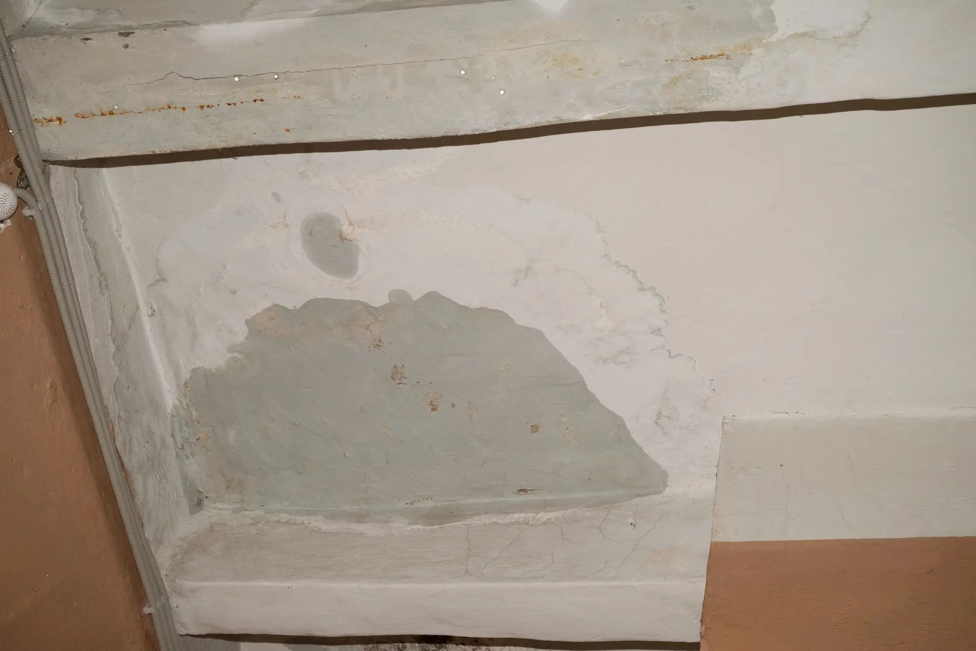 warmer-water-hidden-water-leak-simpsonville Water stain and cracked ceiling corner from a hidden water leak